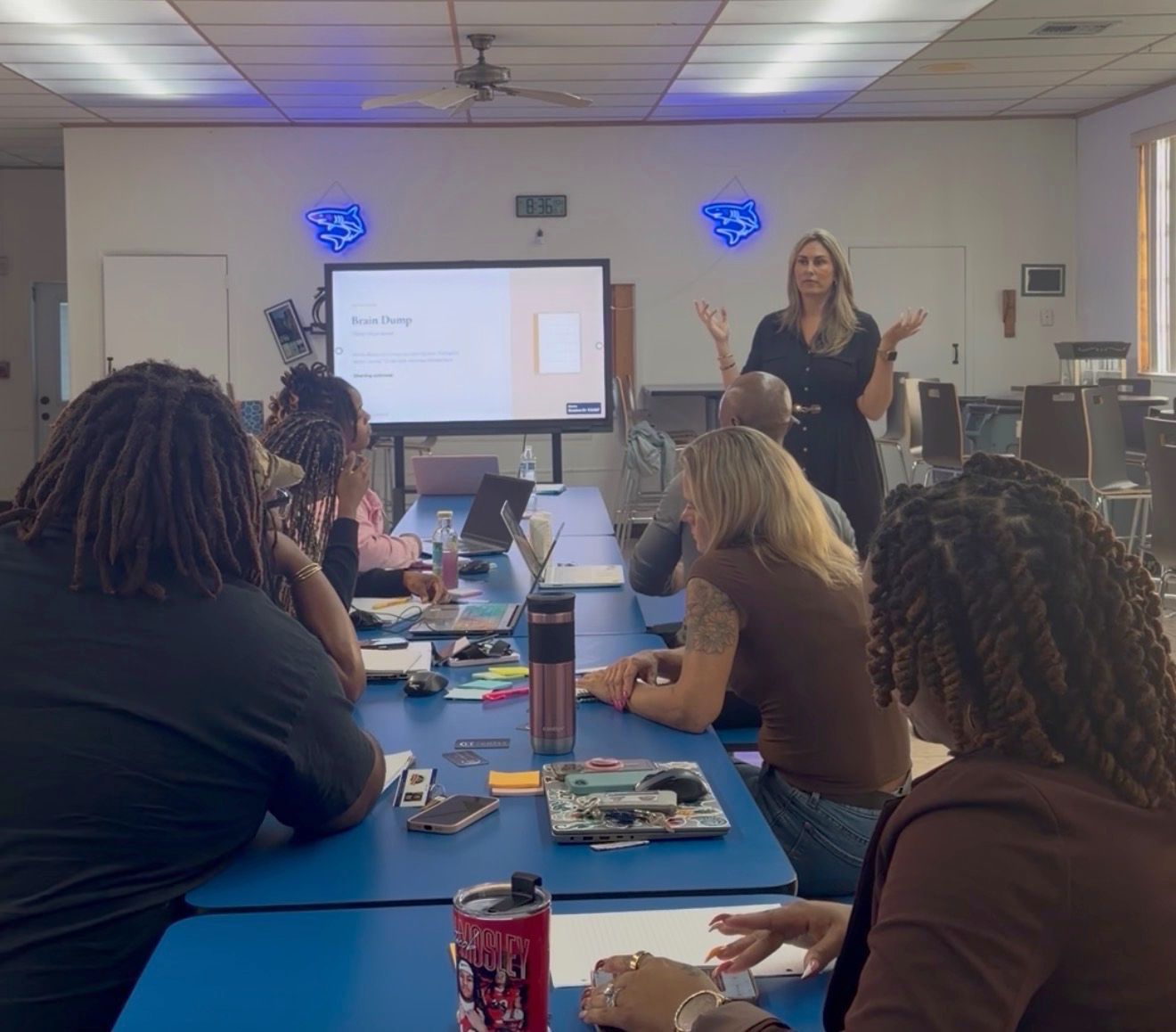 Nicole Meyer leading the Brain Dump activity with staff seated around long tables